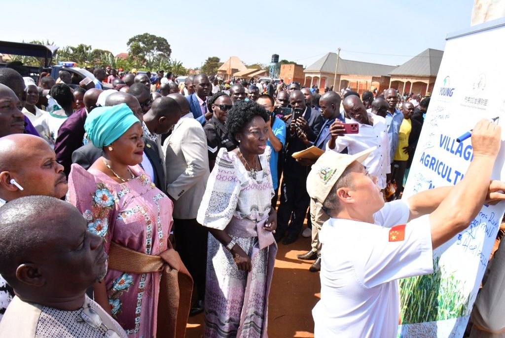 Rt. Hon. Dr. Rebecca Alitwala Kadaga alongside Rt. Hon. Rukia Nakadama, Zhang Xiaogiang the team leader FAO-China Uganda at South-South Cooperation project phase 3 together with other esteemed dignitaries Signing on the raised banner during the commissioning of VAM in Mayuge.