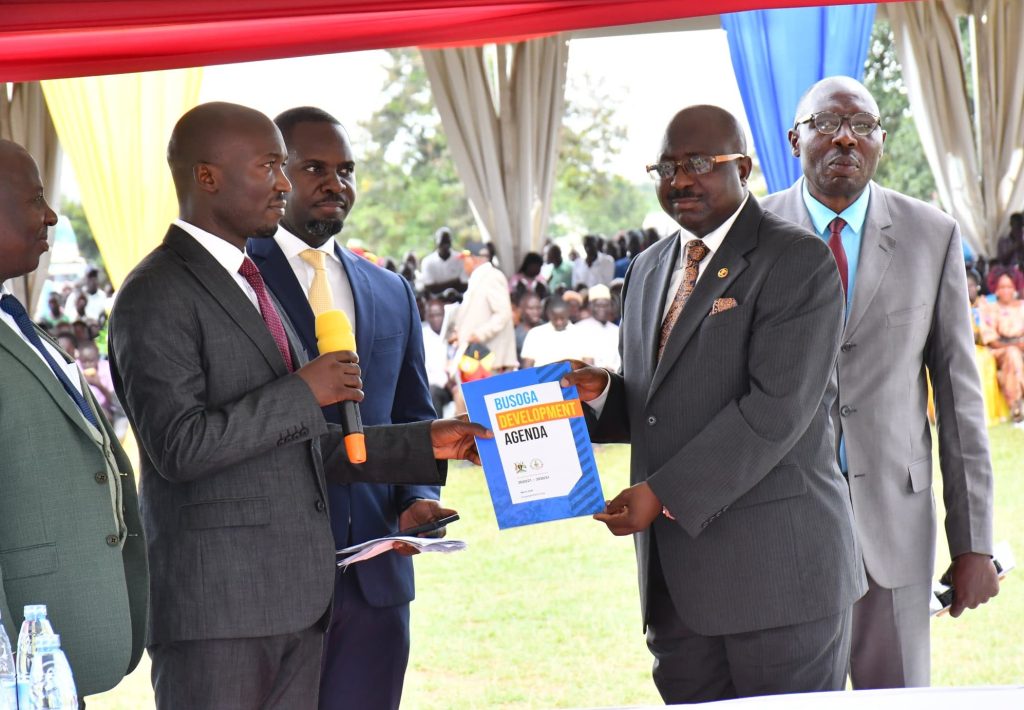 Governor Bishop Frank Tibagendeka District Chairperson Mayuge receiving the BDA during the handle over from Mr. Wakaze Simon of Luuka.