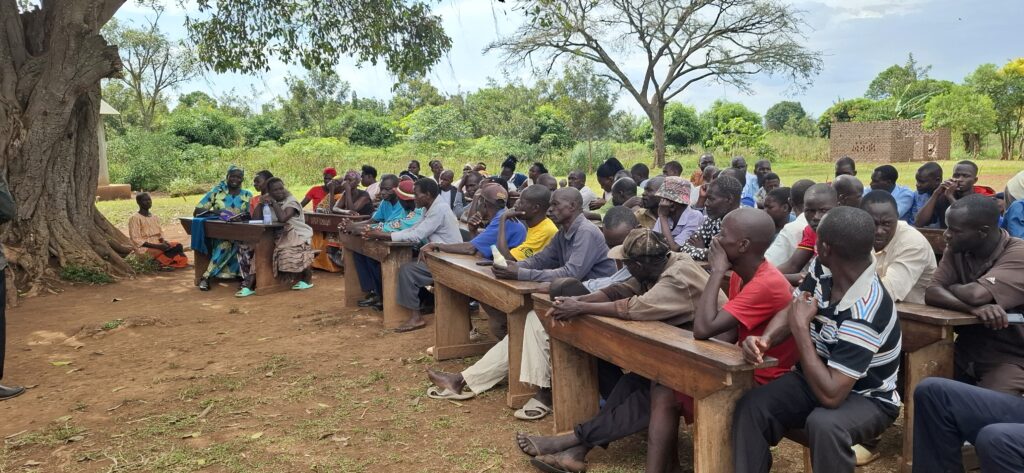 Residents of Namayobe Village, Namayingo District, attentively participating in the community meeting.