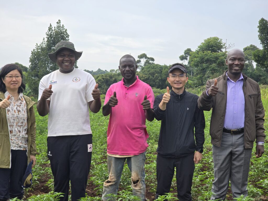 Busoga Consortium and Chinese agriculture experts share a photo moment with young entrepreneurs at their chili and soybean farms during their tour in Busoga.