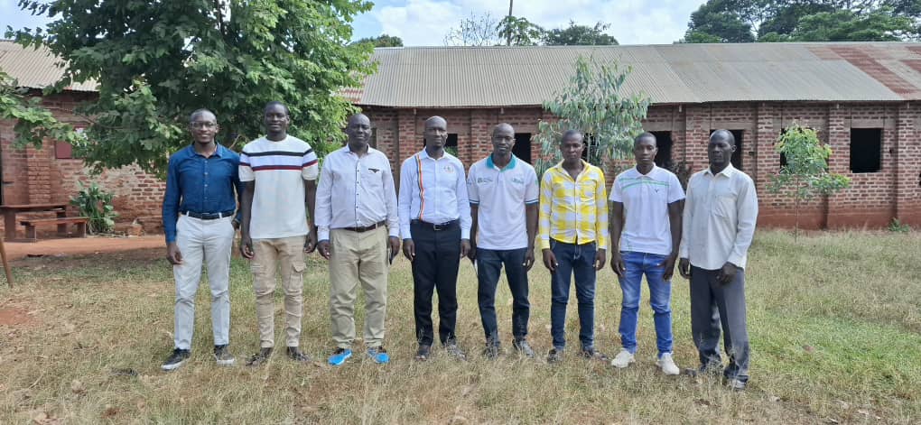 Dr. Mula Anthony, Director General of the Busoga Consortium, together with school leaders led by Headteacher Mr. Makubo Stephen, the Busana Village Action Committee, and district officials during a photo moment at Buteme Light SDA Primary School.