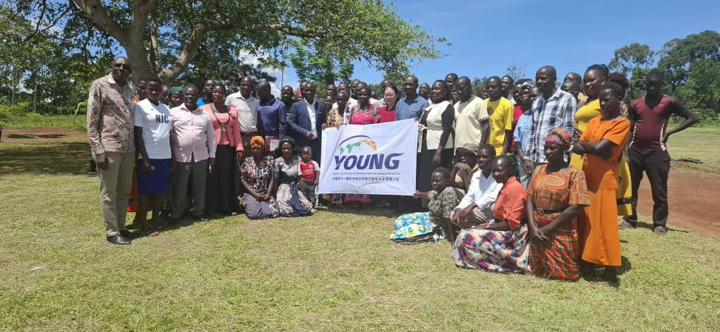 Photo moment of Dr. Li Li, Dr. Mula Anthony, and Mr. Sanya Ronald with BCD–CAU beneficiaries and local farmers during the monitoring tour in Namayombe Village.