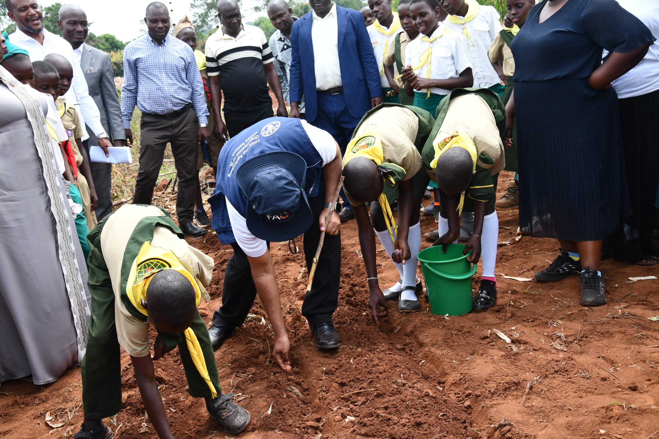 H.E . Ezana Getahun Kassa FAO Country Representative in Uganda planting soya at Buteme Light SDA Primary School garden during the His official monitoring visit to Busana Model Village in Kamuli District. 
