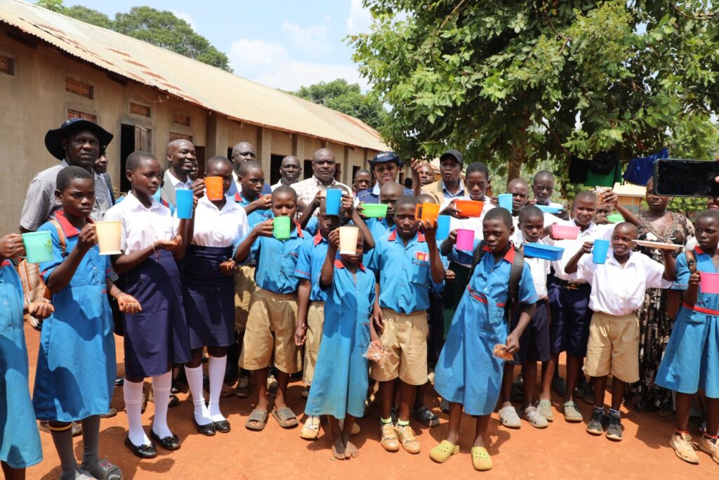  H.E . Ezana Getahun Kassa (c) FAO Country Representative in Uganda, with, Dr. Mula Anthony, (DG/BCD) Hon. Stephen Kisa, HM Mr. Makubo Stephen and District Leadership with pupils of Buteme Light SDA Primary School, group photo during the His official monitoring visit to Busana Model Village in Kamuli District. 